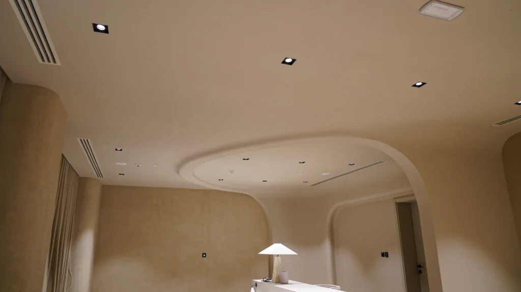 Fluid ceiling design creating visual movement, soft lighting, and a serene aesthetic