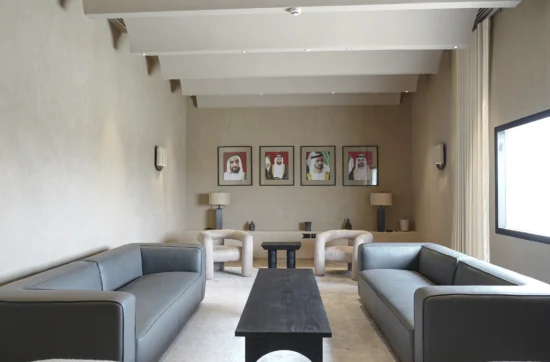 Formal lounge with portraits of UAE leaders, symmetrical layout, and soft beige tones