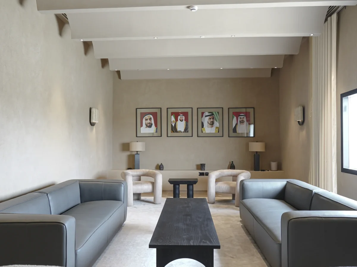 Formal lounge with portraits of UAE leaders, symmetrical layout, and soft beige tones